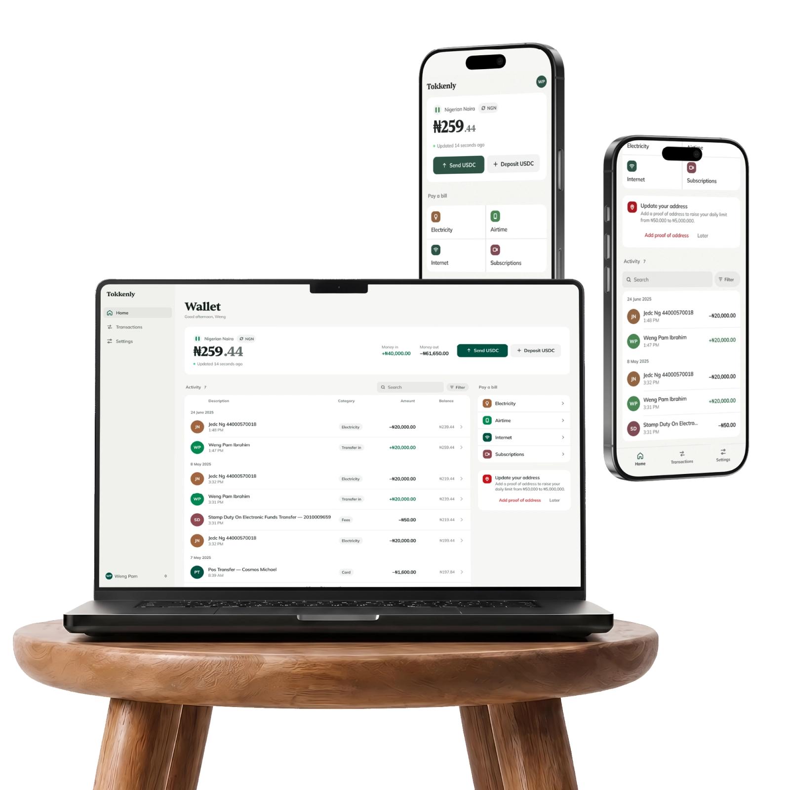 The Tokkenly wallet across a laptop and two phones on a wooden stool.
