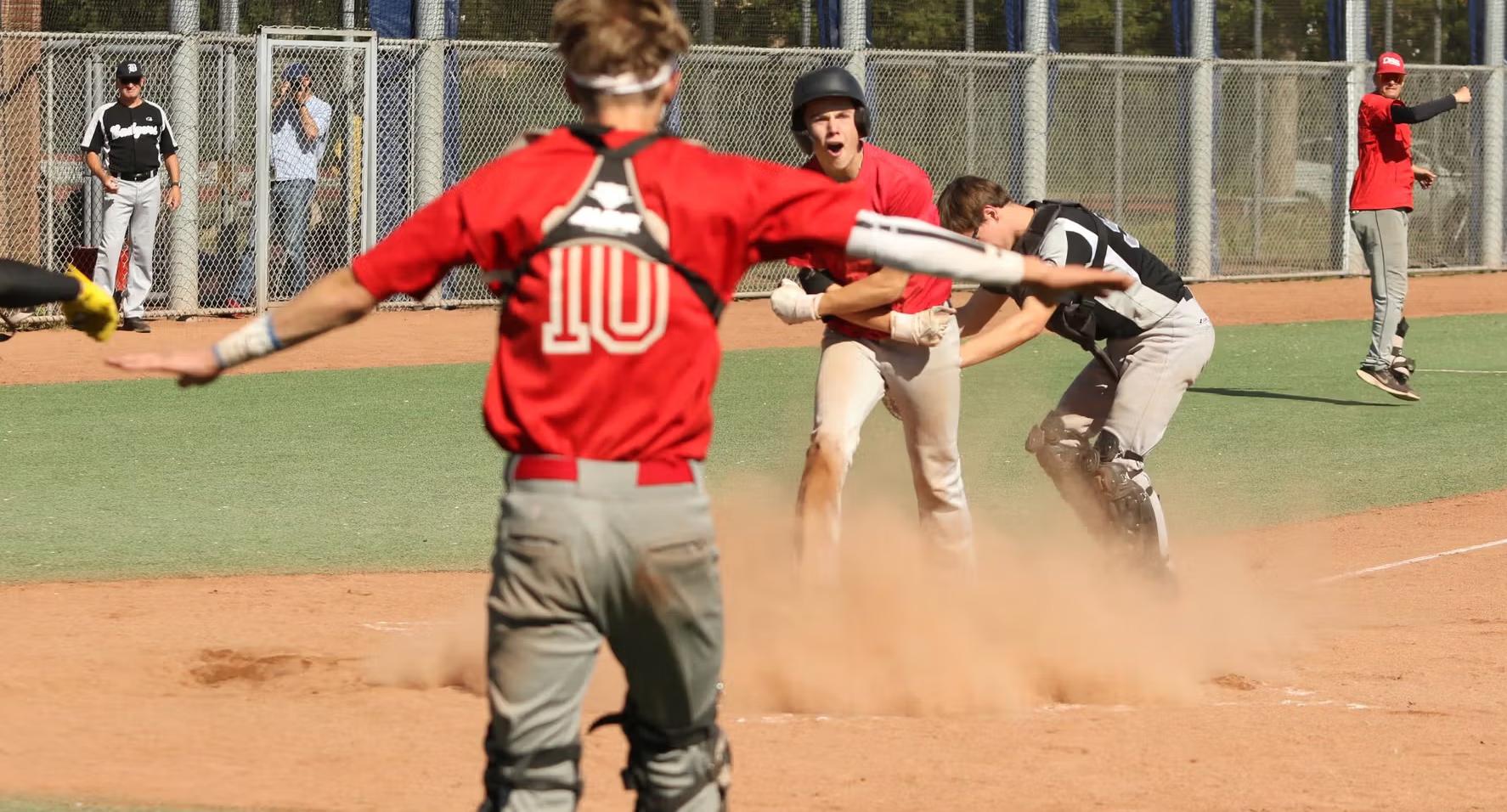 DSS Haarlem honkbalspeler viert een gescoorde run bij de thuisplaat.
