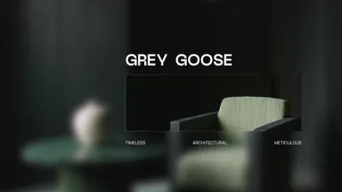 The Grey Goose wordmark over a dark interior with a green armchair, above three words: timeless, architectural, meticulous