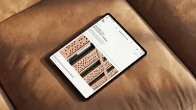 A tablet resting on a tan leather cushion, open on the Grey Goose journal, Notes on Building Well