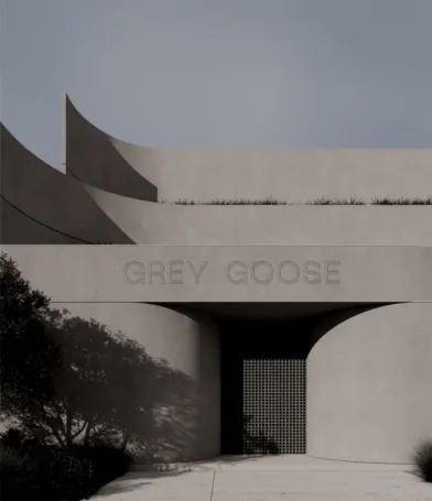 GREY GOOSE lettering set into the rendered facade of a curved concrete home, above a screened entry