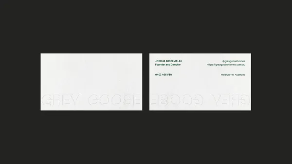 Grey Goose business cards on charcoal, the wordmark blind embossed across the front and back