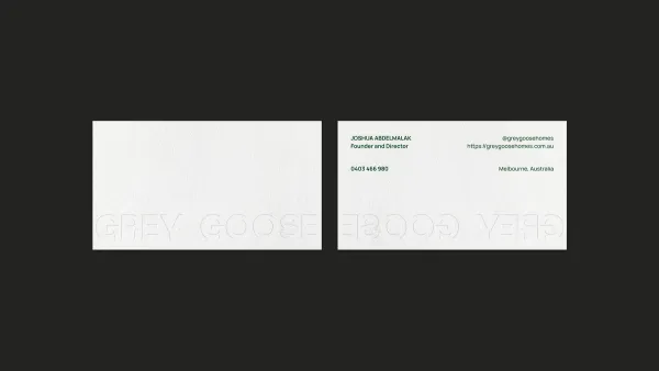 Grey Goose business cards on charcoal, the wordmark blind embossed across the front and back