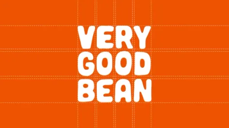 The Very Good Bean wordmark in white on orange, set on its construction grid
