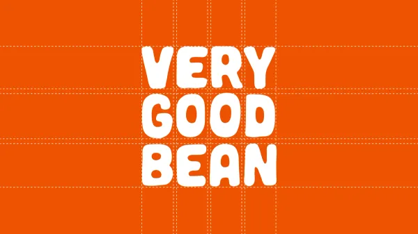The Very Good Bean wordmark in white on orange, set on its construction grid
