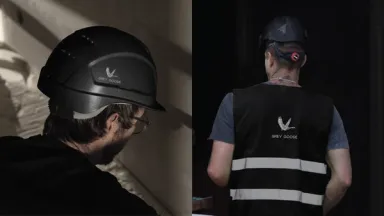 Grey Goose site workwear: a black hard hat and a black hi-vis vest, each carrying the goose mark