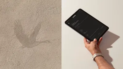 The goose mark pressed into sand-coloured plaster, beside a hand holding a tablet open on the Start a Conversation enquiry page