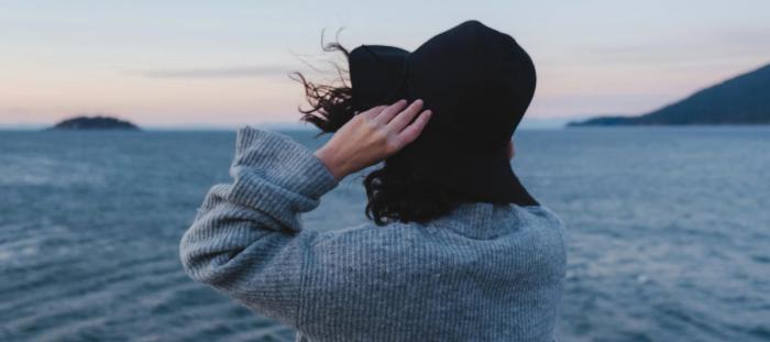 a woman standing on a boat looking out at the ocean
