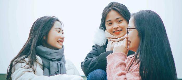 3 Young Women sitting on the ground laughing