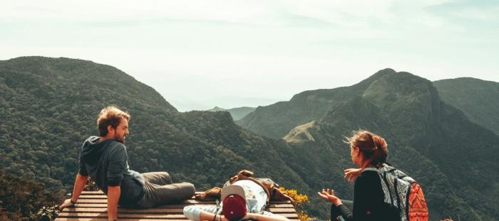 three people overlooking mountains