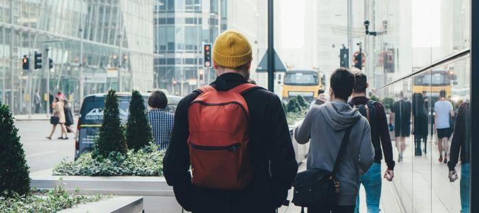 A man walking down a busy sidewalk in a city