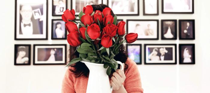 A woman holding a vase full of roses