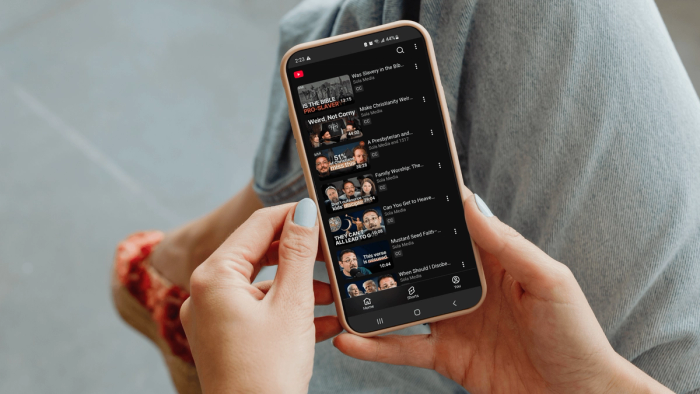 Core Christianity Sola Media Youtube playlist on woman's phone.