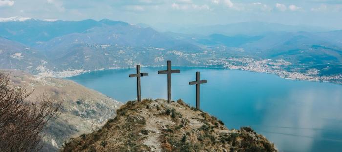 CC-  3 crosses on a hillside overlooking body of water