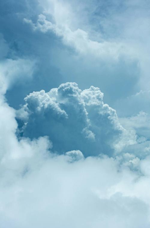 CC- A giant cumulonimbus cloud rises high up into an icy blue sky.