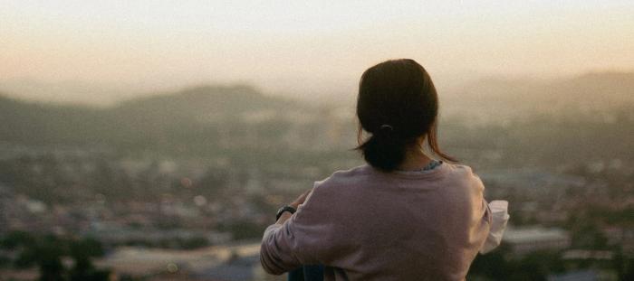 A woman overlooking a town at evening