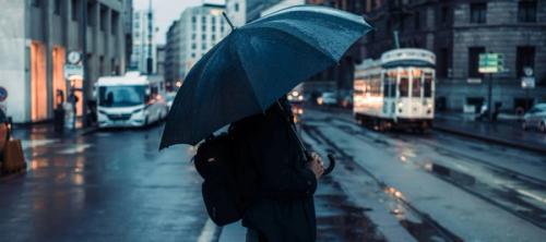 a person standing on a street holding an umbrella