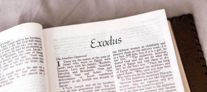 CC- a bible open to the book of Exodus written in large, italicized font, starting at chapter 1 with the chapter heading "The Israelites Oppressed"