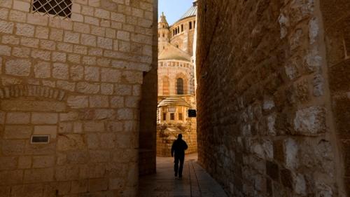 Silhouette of a person walking in an alleyway in the Old City of Jerusalem, Israel.