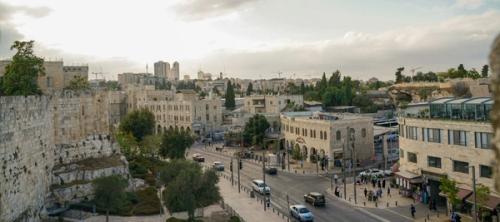 Modern day Jerusalem with cars on the street and people walking around.