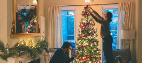 A couple decorating a Christmas tree
