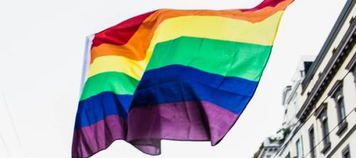rainbow flag in front of black and white building