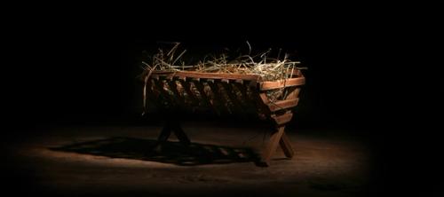 A manger under a spotlight in a dark room