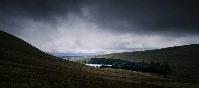 brown mountain under cumulos clouds