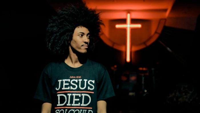 A man wearing a Jesus t-shirt quoting John 10:10.