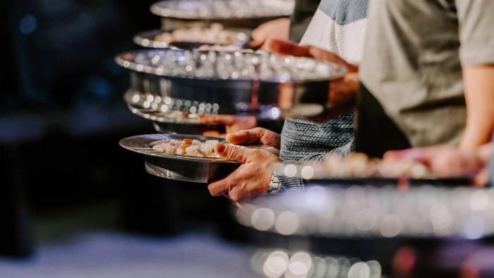 Communion trays held by a row of men at church.