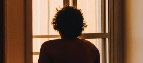 A man sitting and looking out the window.