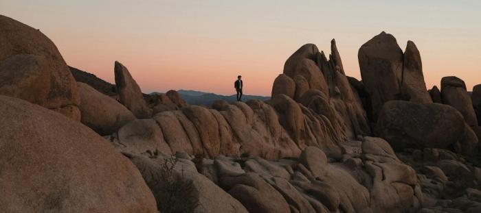 Person standing on rocks during a beautiful sunset.