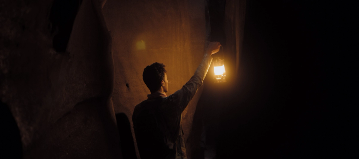 A Man holding a lantern in the dark