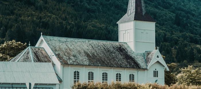 white church in front of a green mountainside