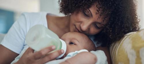 A mother holding and bottle feeding her baby.