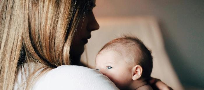 woman in white shirt carrying baby