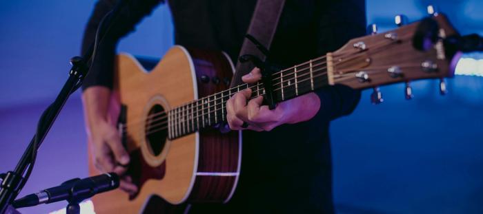 hands strumming a guitar