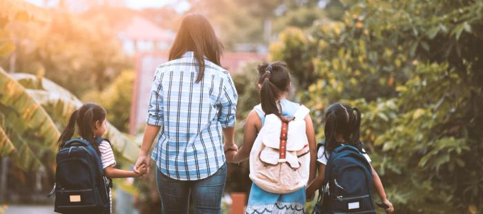 Back to school. Asian mother and daughter pupil girl with backpack holding hand and going to school together in vintage color tone