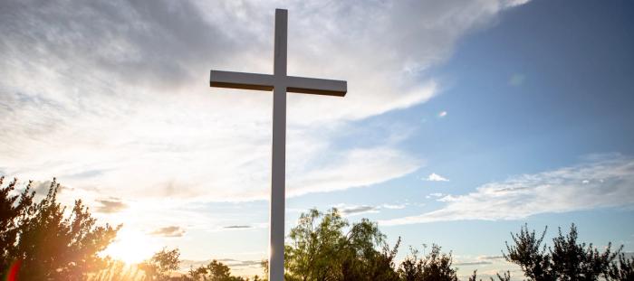 A cross with the rising behind it