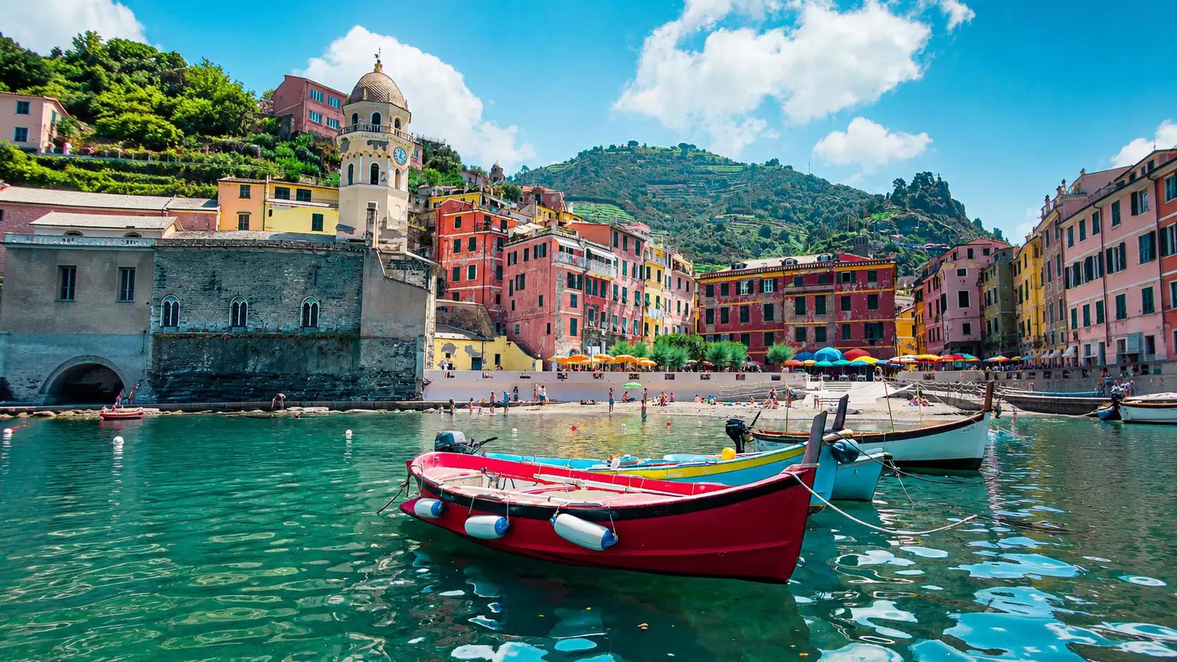 Veduta panoramica del borgo di Vernazza, con la piazza principale affacciata sul porticciolo, la chiesa trecentesca sulla roccia e la torre del Castello Doria in evidenza