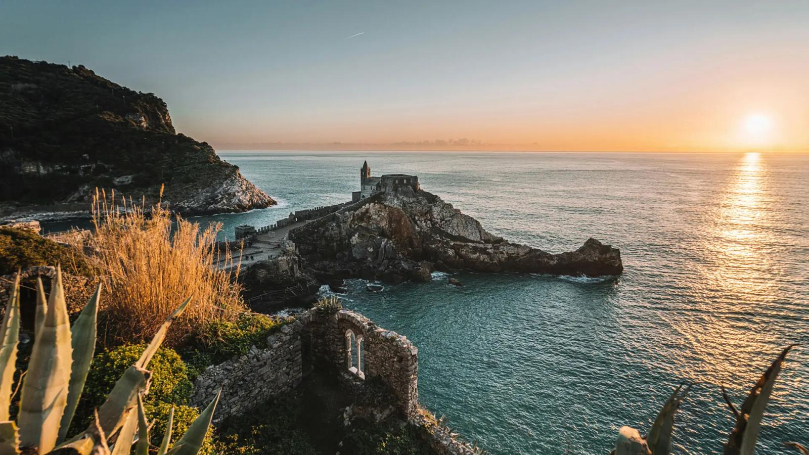 Sentiero AVG5T dell'Infinito tra vigneti terrazzati e panorami sul mare delle Cinque Terre in una limpida giornata.