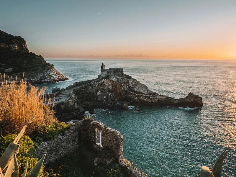 Sentiero AVG5T dell'Infinito tra vigneti terrazzati e panorami sul mare delle Cinque Terre in una limpida giornata.