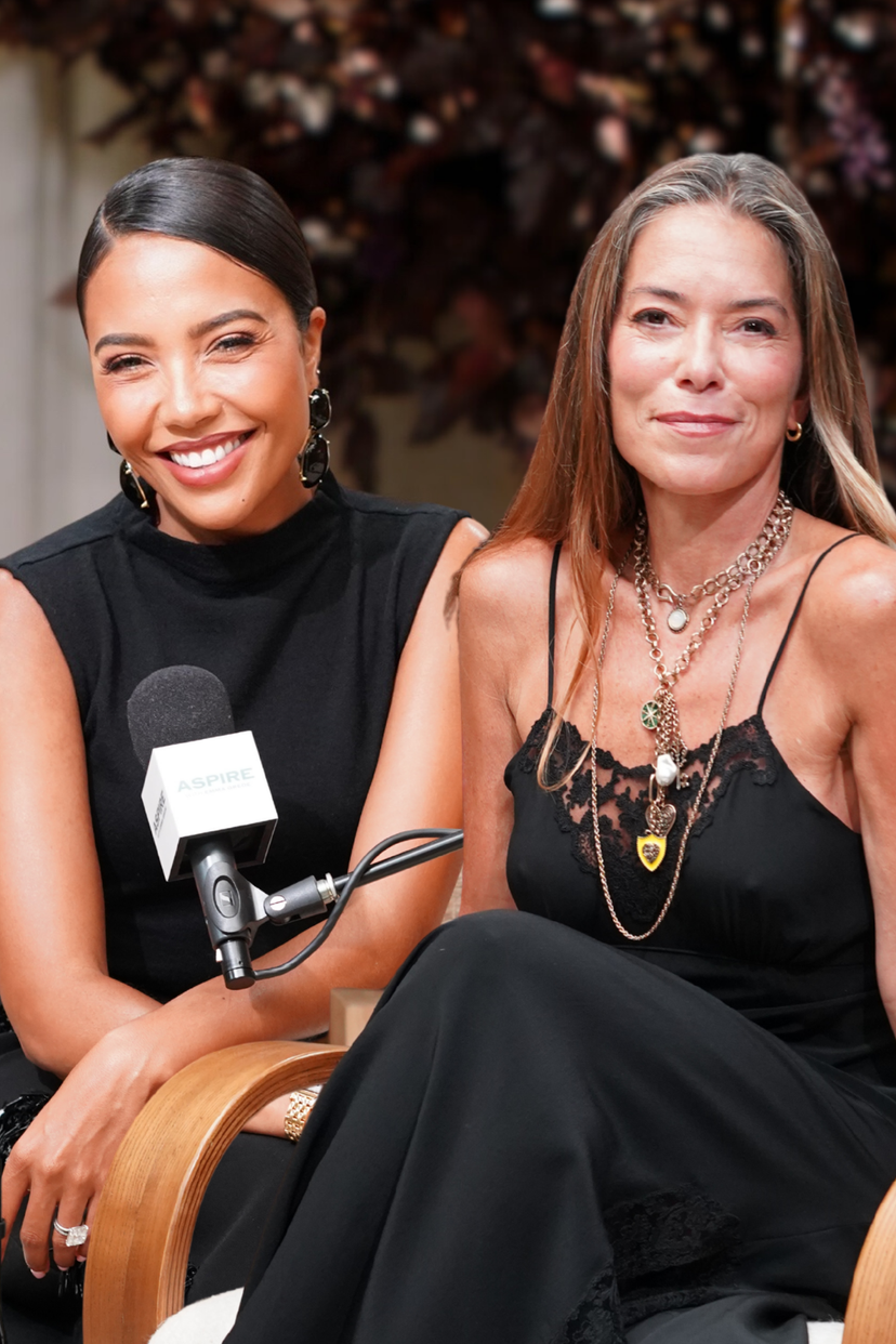 Two women, one with a microphone, sitting below the text "MARRIAGE IS A BUSINESS DEAL w/ Laura Wasser".