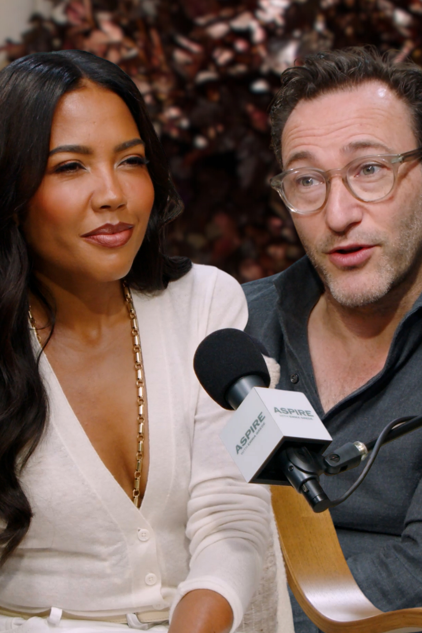 A woman Emma Grede in a white top and a man Simon Sinek in glasses speak into an Aspire branded microphone.