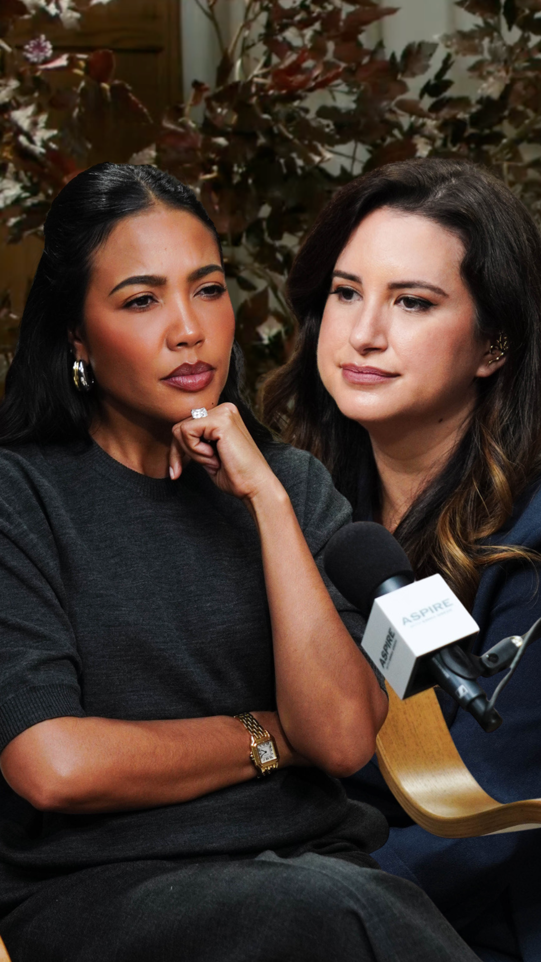 Two women seated, one thoughtfully resting her chin, the other near an Aspire branded microphone.