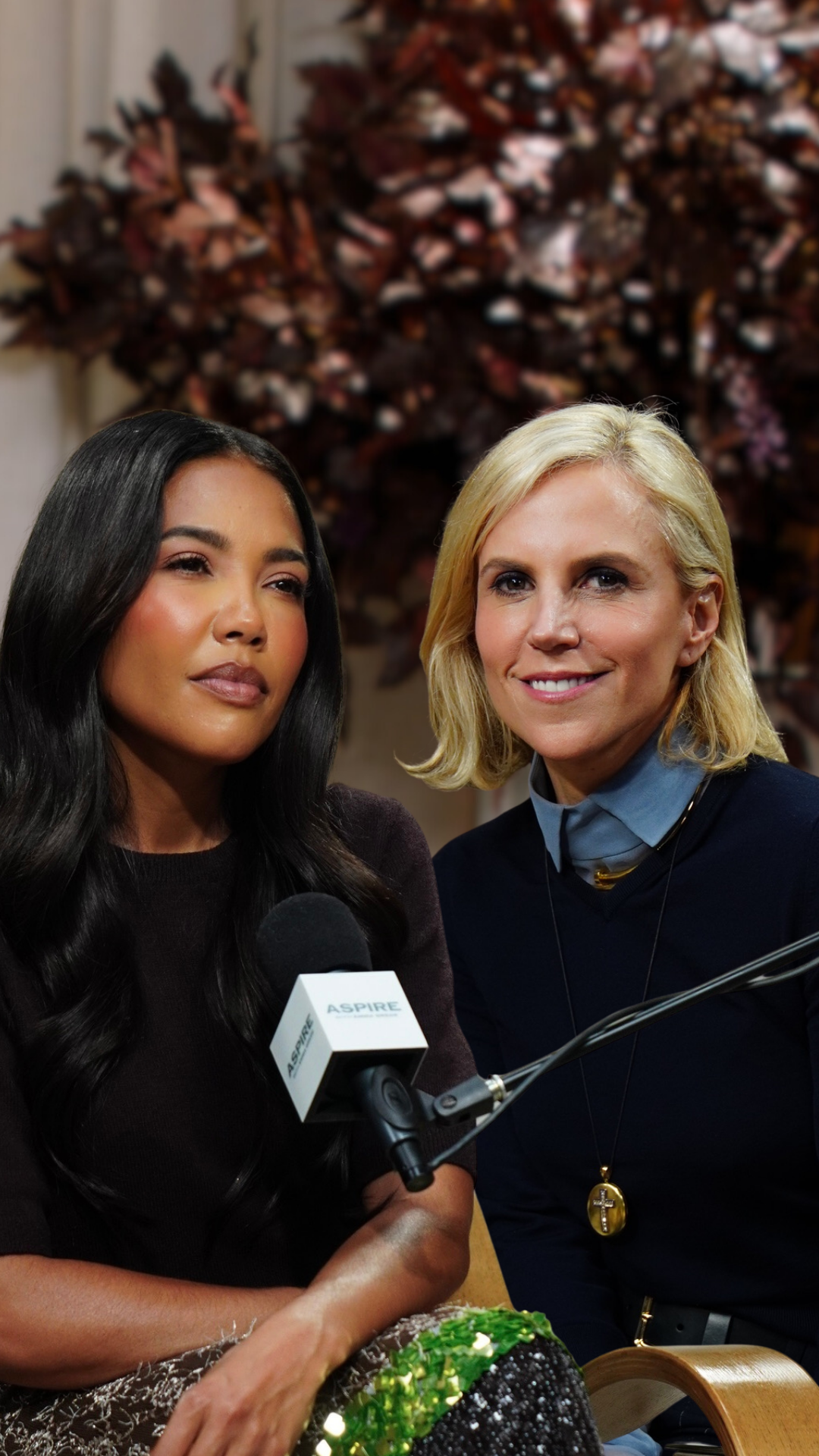 Two women being interviewed: one with long dark hair looking left, and one with a blonde bob smiling, with an ASPIRE microphone between them.