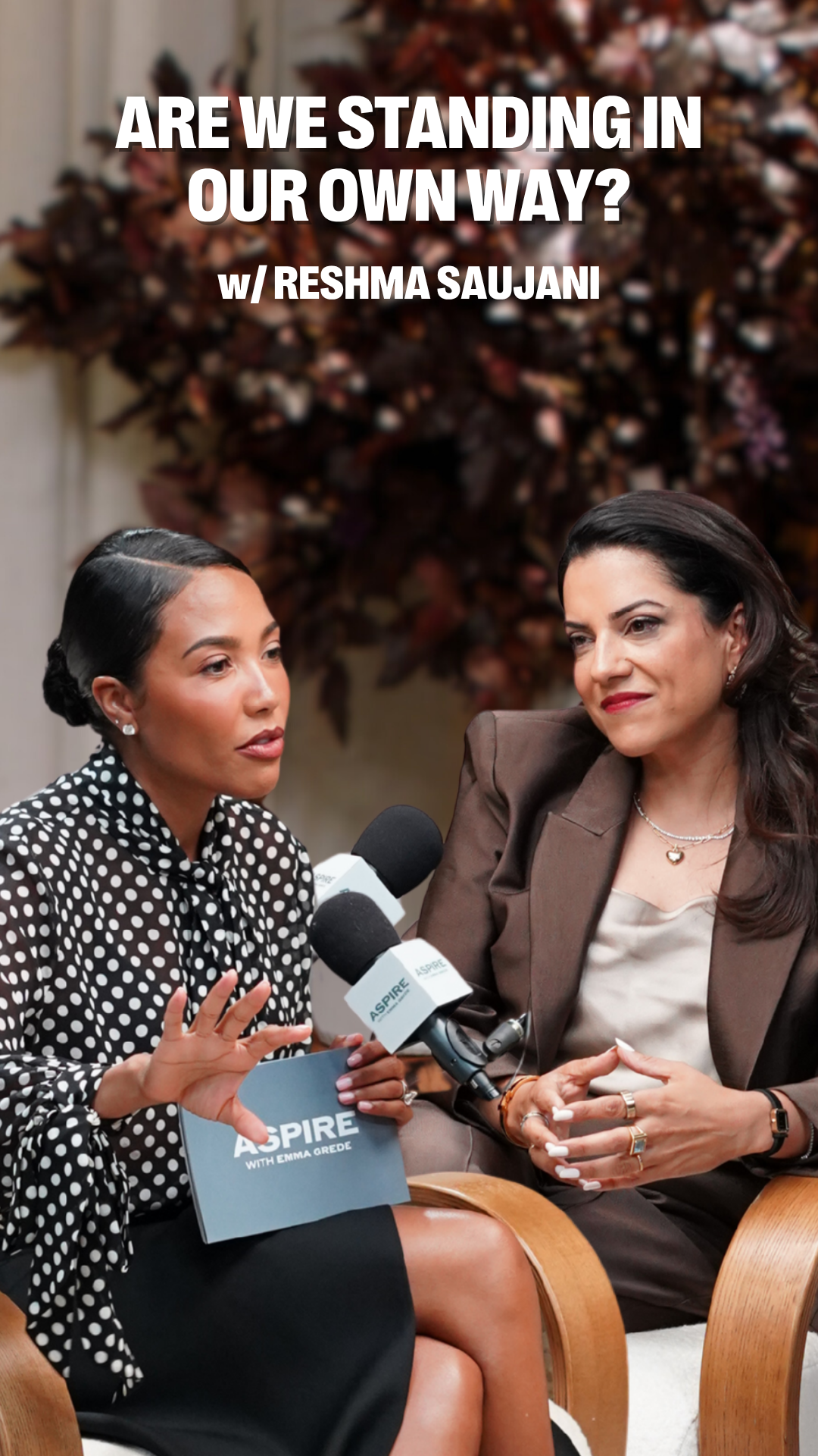 Emma Grede and Reshma Saujani seated for a conversation with microphones, under the title "ARE WE STANDING IN OUR OWN WAY?"