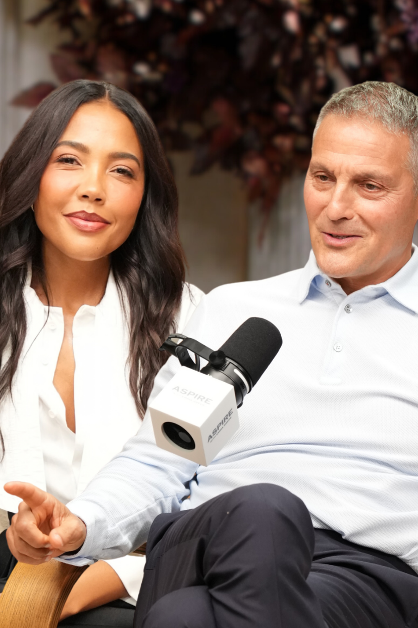 A smiling woman and Ari Emanuel sit in an interview with a microphone. Text overlay reads: DYSLEXIA, RAGE AND BUILDING A HOLLYWOOD EMPIRE w/ Ari Emanuel!