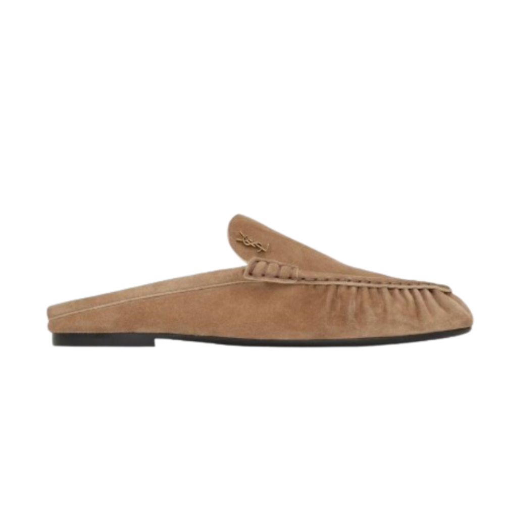 Saint Laurent camel suede slip-on loafer featuring a gathered toe, flat sole, and signature gold-tone YSL monogram hardware.