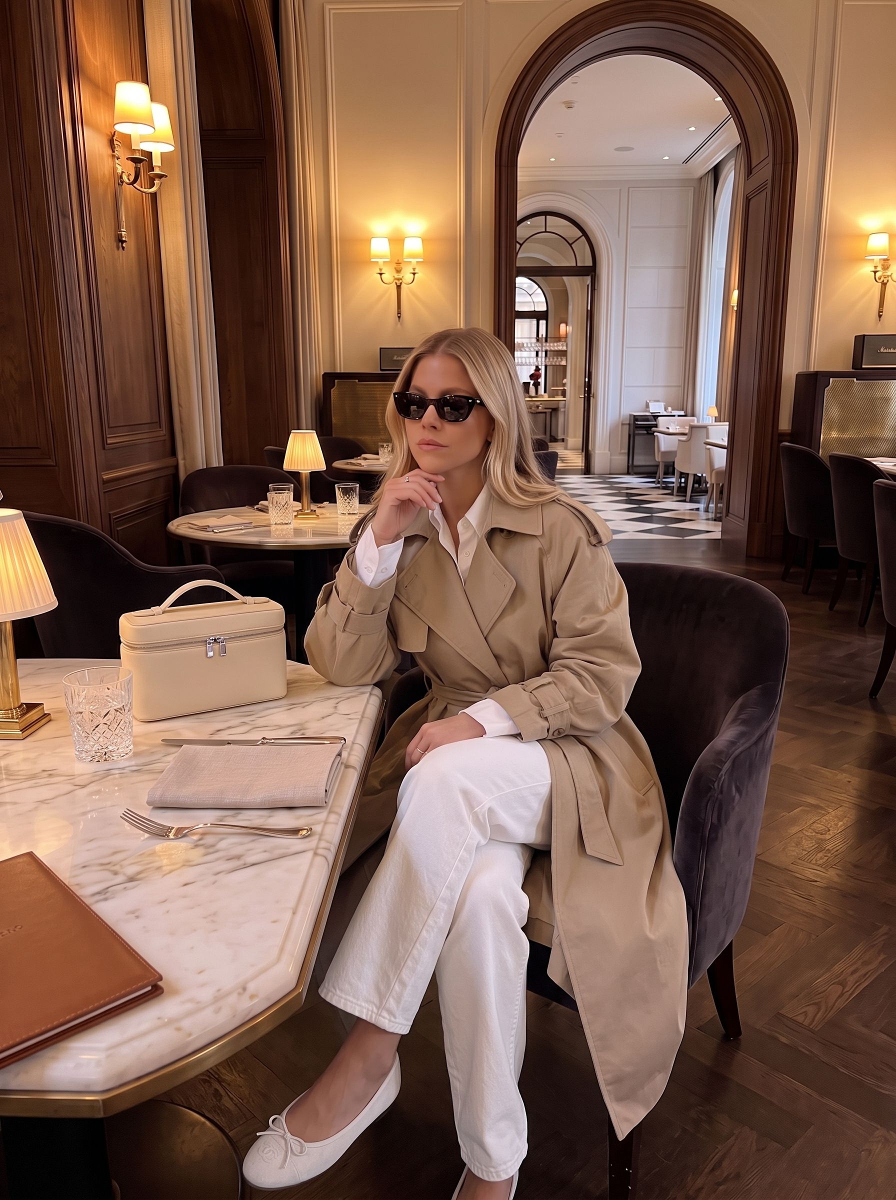Woman modeling a casual fall quiet luxury monochromatic outfit consisting of a cream collared knit sweater, white jeans and beige ballet flats.